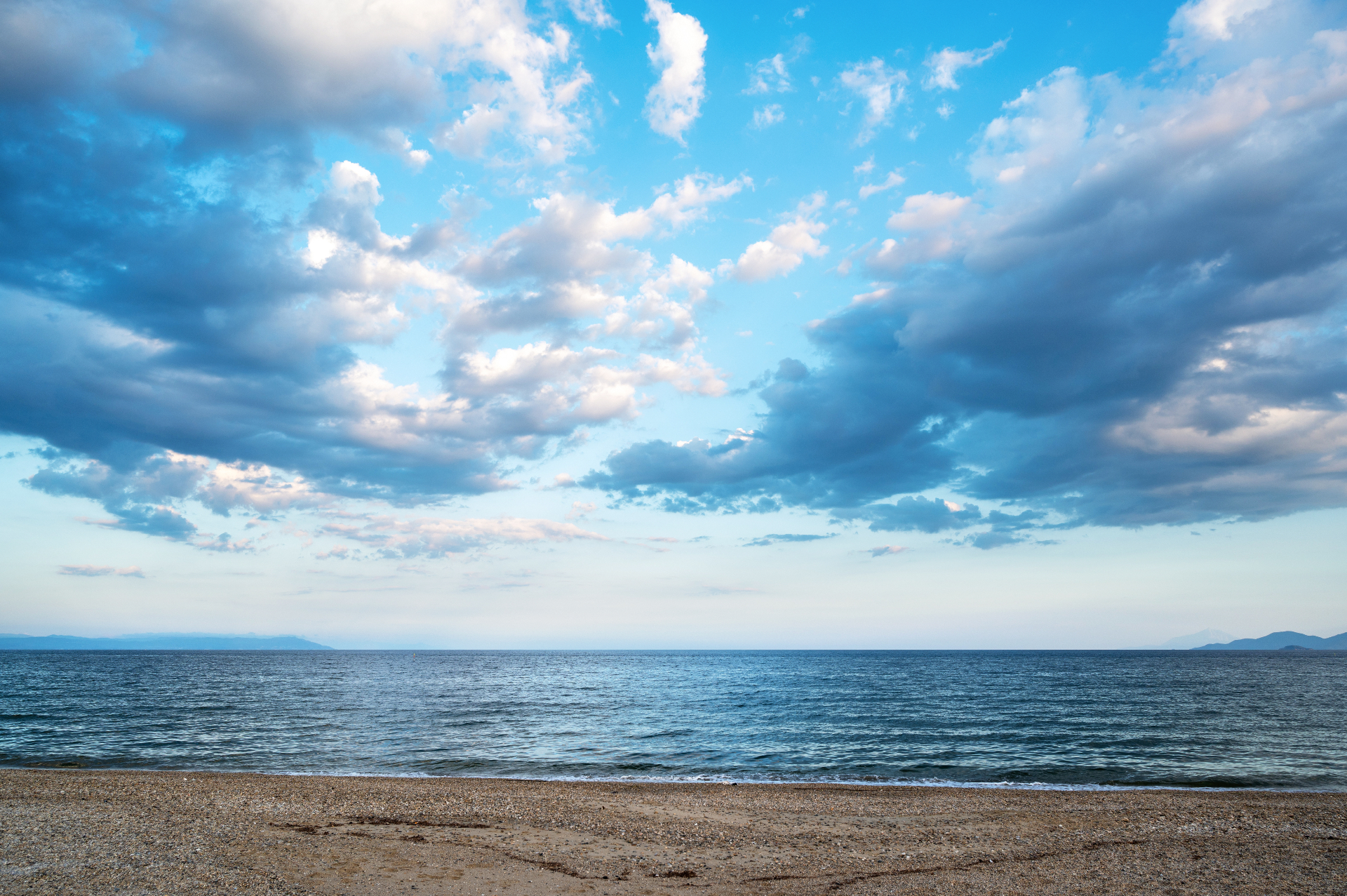 Paisaje de playa con cielo parcialmente nublado sobre el mar